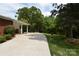 A long concrete driveway winds past a lush lawn and shrubbery, enhancing the home's curb appeal at 8608 Cedarbrook Dr, Charlotte, NC 28215