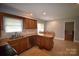 Spacious kitchen with wooden cabinets, granite countertops, stainless steel sink, and a breakfast bar with four chairs at 8608 Cedarbrook Dr, Charlotte, NC 28215