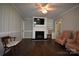 Living room featuring brick fireplace with tv, hardwood floors, soft color walls, and comfortable seating at 8608 Cedarbrook Dr, Charlotte, NC 28215