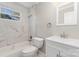 Updated bathroom featuring a marble tiled shower-tub, modern vanity, and bright window at 900 E Woodlawn Rd, Charlotte, NC 28209