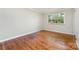Bedroom with hardwood floors and natural light from a large window at 900 E Woodlawn Rd, Charlotte, NC 28209