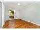 Bedroom features hardwood floors, neutral paint, white trim, and a bright window at 900 E Woodlawn Rd, Charlotte, NC 28209