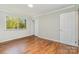 Bright bedroom features hardwood floors, neutral paint, window, white trim and two closets at 900 E Woodlawn Rd, Charlotte, NC 28209