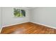 Bright bedroom features hardwood floors, neutral paint, and a window at 900 E Woodlawn Rd, Charlotte, NC 28209