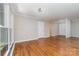 Well-lit living room with hardwood floors, crown molding, and large windows at 900 E Woodlawn Rd, Charlotte, NC 28209