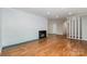 Spacious living room featuring hardwood floors, a brick fireplace, and updated paint at 900 E Woodlawn Rd, Charlotte, NC 28209