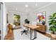 Well-lit home office features a modern desk, stylish decor, and a large window with a view of nature at 900 E Woodlawn Rd, Charlotte, NC 28209