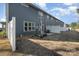 A gray home's backyard offers a white fence, small patio with dining set, and dormant lawn at 9031 Odell Corners Nw Blvd, Concord, NC 28027