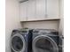 A laundry room showcases a modern washer and dryer set, paired with white cabinets above for efficient storage at 9031 Odell Corners Nw Blvd, Concord, NC 28027