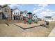 Community playground features a slide, climbing structure, and swing set, nestled between rows of townhomes at 9031 Odell Corners Nw Blvd, Concord, NC 28027