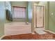 Bathroom showcasing a soaking tub, and a separate glass enclosed shower at 10421 Dominion Village Dr, Charlotte, NC 28269