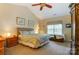 Comfortable bedroom featuring a ceiling fan, vaulted ceiling, and a large window at 10421 Dominion Village Dr, Charlotte, NC 28269