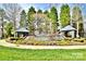Welcoming Highland Creek entrance with stone features, landscaping, and a calming waterfall at 10421 Dominion Village Dr, Charlotte, NC 28269