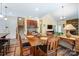 Well-lit dining area with wooden floors, furniture, and a partial view of the staircase and living area at 10421 Dominion Village Dr, Charlotte, NC 28269