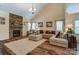 Cozy living room featuring hardwood floors, a stone fireplace, and natural light at 10421 Dominion Village Dr, Charlotte, NC 28269