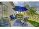 Patio with a blue patio set and umbrella, plus a stack of patio furniture in the corner at 10421 Dominion Village Dr, Charlotte, NC 28269