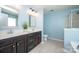 Well-lit bathroom featuring a double sink vanity, tile floors, and a glass-enclosed shower with a decorative mirror at 10694 Sapphire Trl, Davidson, NC 28036