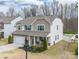 Beautiful two-story house with stone accents, a two-car garage, and a cozy front porch with rocking chairs at 10694 Sapphire Trl, Davidson, NC 28036
