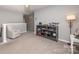 Hallway with grey walls, grey carpet, white railing, and a grey bookshelf filled with collectibles and a grey easy chair at 10694 Sapphire Trl, Davidson, NC 28036