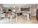 Open-concept kitchen with a central island, dark cabinetry, and an adjacent dining area with seating at 10694 Sapphire Trl, Davidson, NC 28036