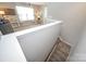 Upstairs landing showcasing a view of a loft area and a staircase with carpeted steps at 10694 Sapphire Trl, Davidson, NC 28036