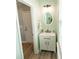 Charming powder room featuring a vanity with storage, framed mirror, and natural light from the window at 10694 Sapphire Trl, Davidson, NC 28036