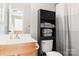 Bright bathroom featuring a white vanity, black cabinet, toilet, and a stylish gray and white curtain at 107 Forester St, Mooresville, NC 28117