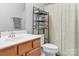 Functional bathroom with a wood vanity, patterned shower curtain, and essential fixtures at 107 Forester St, Mooresville, NC 28117