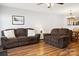Inviting living room featuring dual sofas, hardwood floors, and a seamless transition to the kitchen area at 107 Forester St, Mooresville, NC 28117