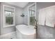 Bathroom with free-standing soaking tub, complemented by large windows offering views of the serene outdoors at 113 Hidden Ln, Mooresville, NC 28117