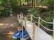 Lake house dock featuring a wooden walkway with rope railing, seating area, and boat at 113 Hidden Ln, Mooresville, NC 28117