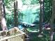 Scenic view of a lake from the backyard, complemented by a wooden dock and inviting outdoor seating at 113 Hidden Ln, Mooresville, NC 28117