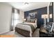 Cozy bedroom with a decorative blue accent wall, carpet, and large window dressed with curtains at 1234 Wendall Ln, Mount Pleasant, NC 28025