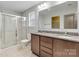 Bathroom showcases a double sink vanity, tiled floors, and a glass enclosed shower at 12706 Ballyliffin Dr, Pineville, NC 28134
