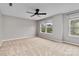 Spacious carpeted bedroom featuring a ceiling fan and natural light through windows at 12706 Ballyliffin Dr, Pineville, NC 28134