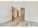 Bright bedroom featuring neutral walls, wood floors, and a doorway leading to another room at 12706 Ballyliffin Dr, Pineville, NC 28134