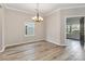 Bright dining area featuring a modern chandelier and an entrance to the sunroom at 12706 Ballyliffin Dr, Pineville, NC 28134