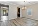 Inviting dining area with wood floors and a chandelier, adjacent to the kitchen at 12706 Ballyliffin Dr, Pineville, NC 28134