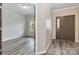 A spacious entryway with a dark brown door and wood-look floors flowing into the living area at 12706 Ballyliffin Dr, Pineville, NC 28134