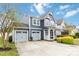 Charming two-story home with a two car garage, well-maintained lawn, and light blue siding at 12706 Ballyliffin Dr, Pineville, NC 28134