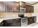 Gourmet kitchen boasts stainless steel appliances, dark cabinetry, and granite countertops at 12706 Ballyliffin Dr, Pineville, NC 28134