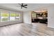 Open-concept living room adjacent to modern kitchen with hardwood flooring and modern fixtures at 12706 Ballyliffin Dr, Pineville, NC 28134
