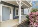 Charming porch featuring white railings, a light blue door, and well manicured landscaping at 12706 Ballyliffin Dr, Pineville, NC 28134