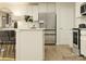 Modern kitchen with stainless steel appliances, white cabinets, light hardwood floors, and stylish island seating at 135 Wheeler Trl, Statesville, NC 28625