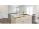 Kitchen island featuring a stainless steel sink, granite countertops, and white cabinets at 142 Jacobs Hill Pl, Troutman, NC 28166