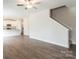 Open-concept living area with hardwood floors, white walls, and a modern kitchen at 142 Jacobs Hill Pl, Troutman, NC 28166