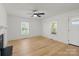 Open living room with hardwood floors, white walls, and a fireplace, plus natural light from two windows at 1545 7Th Avenue Sw Dr, Hickory, NC 28602