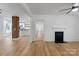 Bright living room featuring hardwood floors, fireplace, and open doorway with exposed brick pillar to the kitchen at 1545 7Th Avenue Sw Dr, Hickory, NC 28602