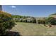 Large backyard with green grass, landscaping, and the rear of adjacent houses at 16524 Palisades Commons Dr, Charlotte, NC 28278