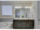 Bathroom featuring a double sink vanity, soaking tub, and neutral color palette at 16524 Palisades Commons Dr, Charlotte, NC 28278
